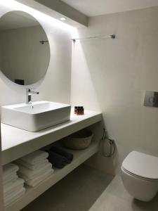 a bathroom with a sink and a toilet and a mirror at Fourteen All Seasons House in Chania