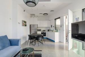 ein Wohnzimmer mit einem Sofa und einem Tisch sowie eine Küche in der Unterkunft Unique Urban Villa - Live Local with Style in Tel Aviv