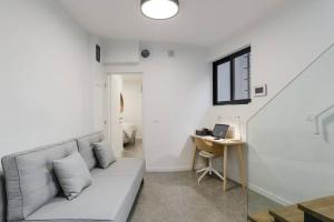 ein Wohnzimmer mit einem Sofa und einem Schreibtisch in der Unterkunft Unique Urban Villa - Live Local with Style in Tel Aviv