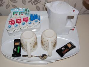 a tray with a tea kettle and a spoon at Atlantis Hotel in Blackpool
