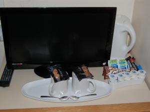 a desk with a computer monitor and two coffee mugs at Atlantis Hotel in Blackpool