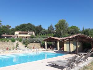 a swimming pool with chairs and a pavilion at Les Cerises in Saint-Saturnin-lès-Apt