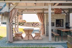 a patio with a table and chairs and a fireplace at Sielsko Anielsko in Białka Tatrzanska