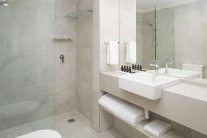 a bathroom with a sink and a shower at Rydges Darling Square Apartment Hotel in Sydney