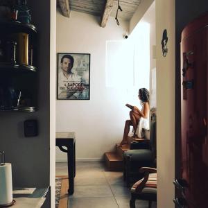 a woman sitting on a chair in a room at Ad Hoc Rooms in Palermo