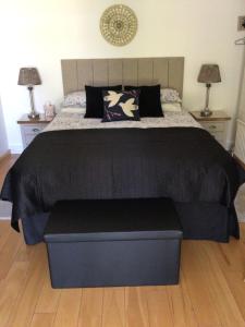 a bedroom with a large bed with a black comforter at Forest B & B in Ringwood