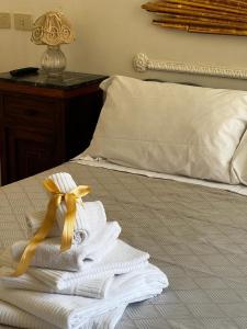 a pile of towels sitting on top of a bed at Narì Bed&Breakfast in Gaeta