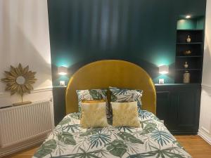 a bedroom with a bed with a yellow headboard and pillows at L'AMAZONIE - Lovely apartment near to the train station and Orly Airport in Juvisy-sur-Orge