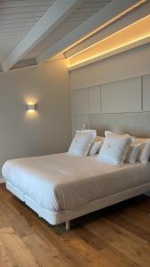 ein großes Bett mit weißen Kissen in einem Zimmer in der Unterkunft De la Osa Hotel 