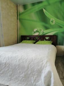 クレメンチュークにあるApartments on Gagarina streetの緑の壁のベッドルーム1室(白いベッド1台付)