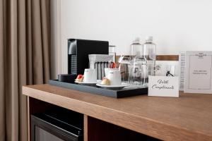 a counter in a hotel room with a coffee maker and glasses at Villa Flavia Heritage Boutique Hotel in Plovdiv