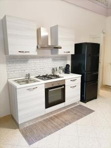 una cucina con un lavello e un frigorifero nero di Da Zio Lello a Martina Franca