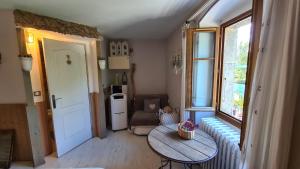 ein kleines Wohnzimmer mit einem Tisch und einem Fenster in der Unterkunft Le Doux Nid in Chanaz