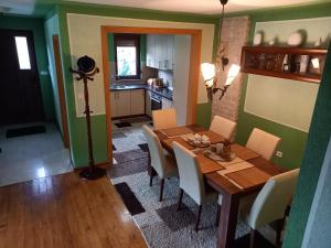 - une salle à manger avec une table et des chaises en bois dans l'établissement Villa Drinski biser sa bazenom, à Višegrad