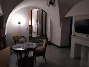 a living room with a table and chairs and a tv at Pokoje Nad Arkadami in Zamość