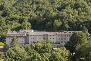 un gran edificio en medio de árboles en Hotel Monte Meraviglia, en Cascia