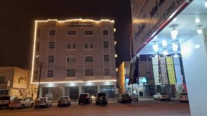 a building with cars parked in front of it at night at Today House Suites 2 in Salalah