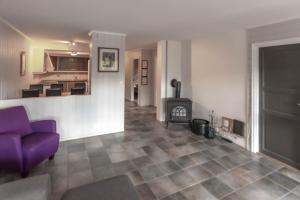ein Wohnzimmer mit einem lila Sofa und einem Kamin in der Unterkunft Bakkebyvegen 1D in Trysil