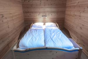 a bedroom with two beds in a wooden room at Bakkebyvegen 1D in Trysil