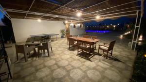 a room with tables and chairs and a ping pong table at Encanto getaway in Sheikh Zayed