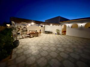 a patio with a table and chairs at night at Encanto getaway in Sheikh Zayed