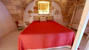 een bed in een kamer met een rode deken bij Corte SantAngelo 15 in Tricase