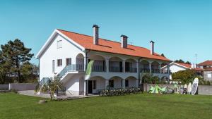 een groot wit huis met fietsen in de tuin bij Private Gardened House - 5min from the beach in Viana do Castelo