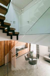 uma escada de vidro numa sala de estar com uma mesa e cadeiras em Residence Soča em Soca