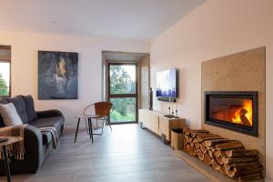 a living room with a couch and a fireplace at Portugal Active Armadas Lodge in Caminha