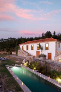 a house with a swimming pool in front of a house at Portugal Active Armadas Lodge in Caminha