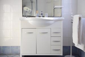 y baño con lavabo blanco y espejo. en Appartamento Sea View Adriana, en Marina di Campo