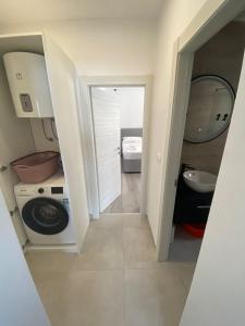 a bathroom with a washing machine and a sink at Apartman MariLu in Drašnice