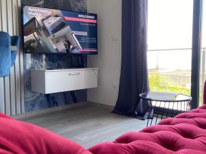 Apartman MariLu في Drašnice: غرفة معيشة مع أريكة حمراء وطاولة