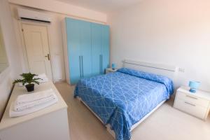 a bedroom with a blue bed and a desk at Appartamento Sea View Adriana in Marina di Campo