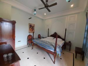 a bedroom with a bed and a ceiling fan at Raj Rajeshwari Haveli in Jaipur