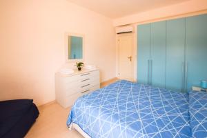 a bedroom with a blue bed and a white dresser at Appartamento Sea View Adriana in Marina di Campo
