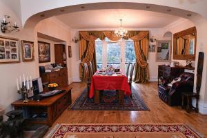 a living room with a table with a red table cloth at Luxury Suite in quiet countryside location in Swansea