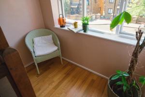 una silla verde sentada en una habitación con ventana en Portobello Corner, en Londres