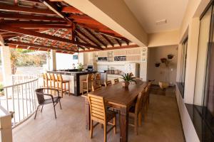 Il comprend une cuisine et une salle à manger avec une table et des chaises en bois. dans l'établissement Hospedaria do Lago, à Espirito Santo Do Pinhal