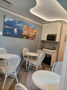 a room with tables and chairs and a kitchen at B&B Federico Secondo in Naples