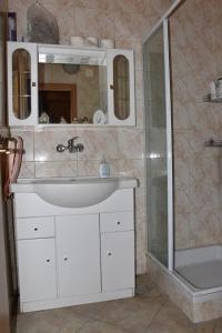 y baño con lavabo blanco y ducha. en Podklanci, en Knežak