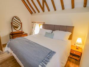 a bedroom with a large white bed and a mirror at Munderfield Mill in Bromyard