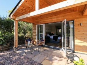 a wooden house with a patio with a bedroom at The Lodge at Middleton House in Church Leigh