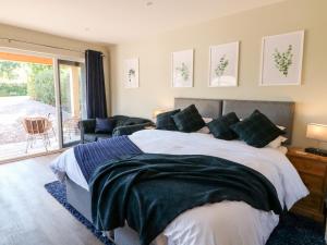 a bedroom with a large bed and a sliding glass door at The Lodge at Middleton House in Church Leigh