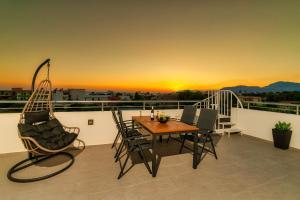 patio con mesa y sillas en el balcón en Ephantasy Living - Luxury home with roof garden en Kalamaki