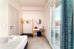 1 dormitorio con cama, escritorio y ventana en Ephantasy Living - Luxury home with roof garden, en Kalamaki