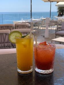 due cocktail seduti su un tavolo in un ristorante di Hôtel Calavita Rooftop & Spa a Bastia