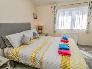 a bedroom with a bed with two towels on it at Brighter Daze in Bridlington