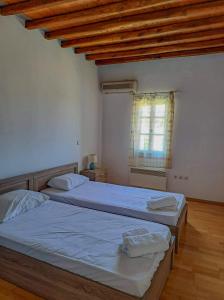 um quarto com 2 camas e uma janela em Sympopoula House em Sifnos