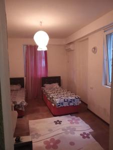 una piccola stanza con un letto e una finestra di Gostevoi dom Batumi. a Batumi